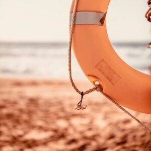 Life buoy on a beach symbolizing support and stability during online therapy while traveling or abroad